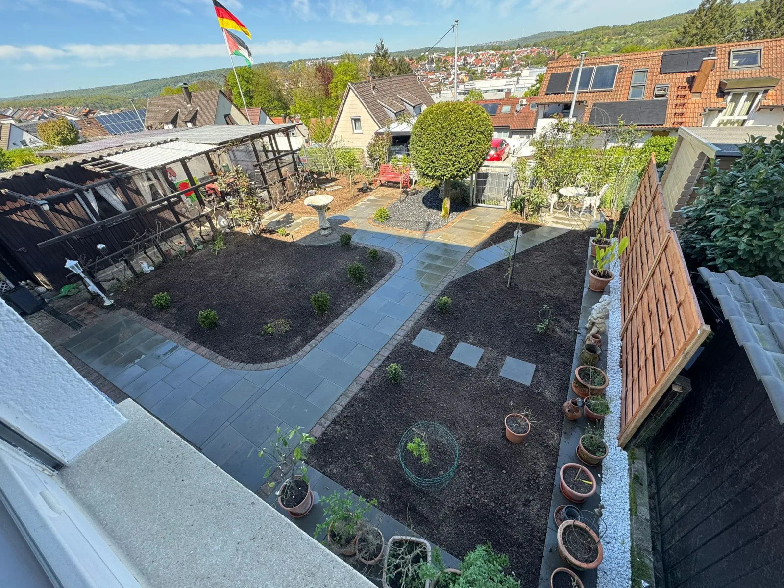 Neu gestalteter Garten mit Plattenwegen, Beeten und Terrasse von oben
